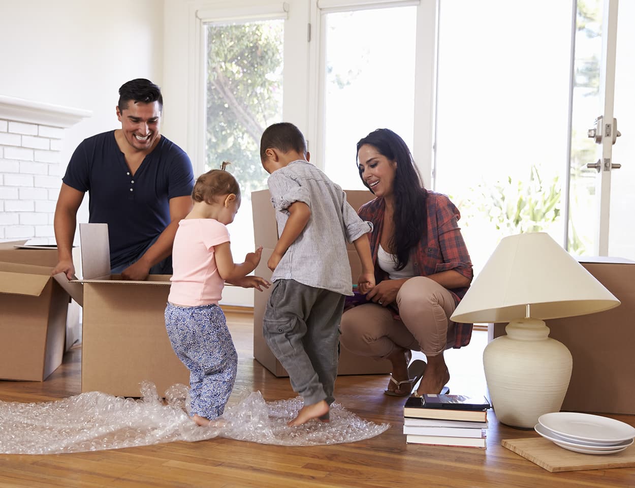 Happy family unpacking boxes in new home